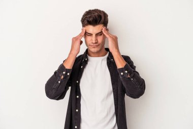 Beyaz arka planda izole edilmiş genç beyaz bir adam tapınaklara dokunuyor ve başı ağrıyor..