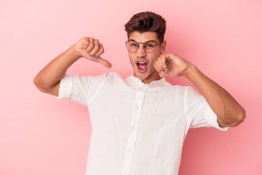 Pembe arka planda izole edilmiş genç beyaz adam gururlu ve kendinden emin hissediyor, örnek olarak.