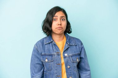 Mavi arka planda izole edilmiş genç Latin kadın üzgün, ciddi yüz, mutsuz ve hoşnutsuz hissediyor.