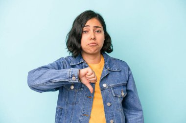 Mavi arka planda izole edilmiş genç Latin bir kadın hoşlanmadığı bir hareket gösteriyor. Anlaşmazlık konsepti.