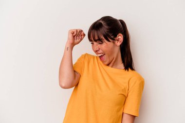 Genç Arjantinli kadın beyaz arka planda izole edilmiş zafer, tutku ve coşkuyu kutluyor, mutlu bir ifade..