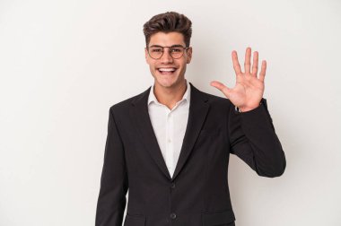 Beyaz arka planda izole edilmiş beyaz bir beyaz iş adamı gülümseyerek beş numarayı parmaklarıyla gösteriyor..