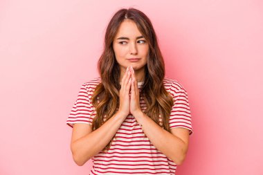 Kafkasyalı genç bir kadın pembe arka planda izole edilmiş bir plan yapıyor, bir fikir kuruyor..