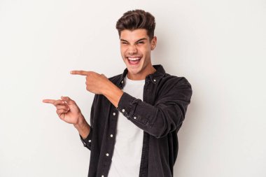 Beyaz arka planda izole edilmiş genç beyaz bir adam işaret parmağıyla işaret ettiği için heyecanlı..