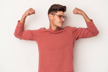 Beyaz arka planda izole edilmiş genç beyaz bir adam güçlü bir hareket gösteriyor, kollarıyla, kadınsı gücün sembolü.