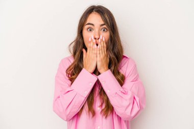 Beyaz arka planda izole edilmiş beyaz tenli genç bir kadın elleri endişeli bir şekilde ağzı örtüyor..