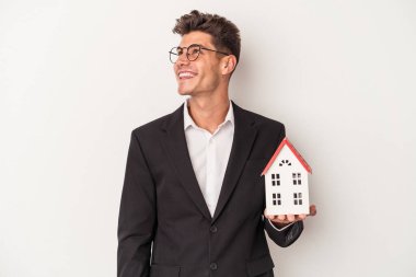 Beyaz arka planda izole edilmiş genç bir beyaz emlakçı hedeflerine ve amaçlarına ulaşma hayali kuruyor.