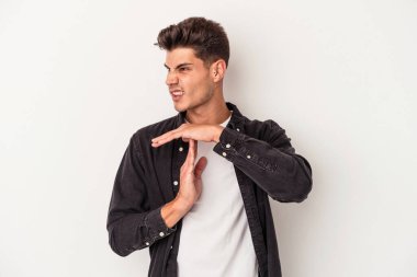 Beyaz arka planda izole edilmiş genç beyaz bir adam bir mola hareketi gösteriyor..