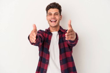 Beyaz arka planda izole edilmiş genç beyaz adam kameraya sarıldığı için kendinden emin hissediyor..