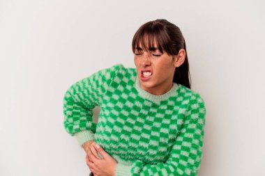 Beyaz arka planda karaciğer ağrısı ve karın ağrısı çeken genç bir Arjantinli kadın..