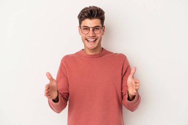 Beyaz arka planda izole edilmiş beyaz bir adam iki eliyle bir şey tutuyor..