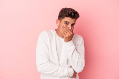 Pembe arka planda izole edilmiş genç beyaz adam korkmuş ve korkmuş..