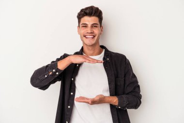 Beyaz arka planda izole edilmiş beyaz bir adam iki eliyle bir şey tutuyor..