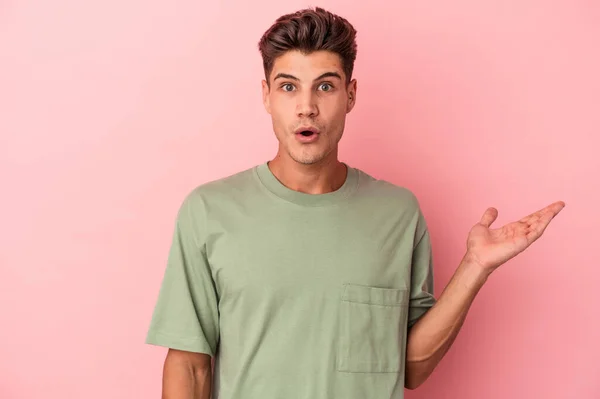 Young Caucasian Man Isolated Pink Background Impressed Holding Copy Space — Stock Photo, Image