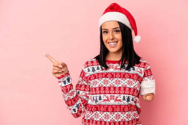 ピンクの背景に孤立したクリスマスを祝う一つの腕を持つ若い白人女性笑顔と脇を指して 空白のスペースで何かを示す — ストック写真
