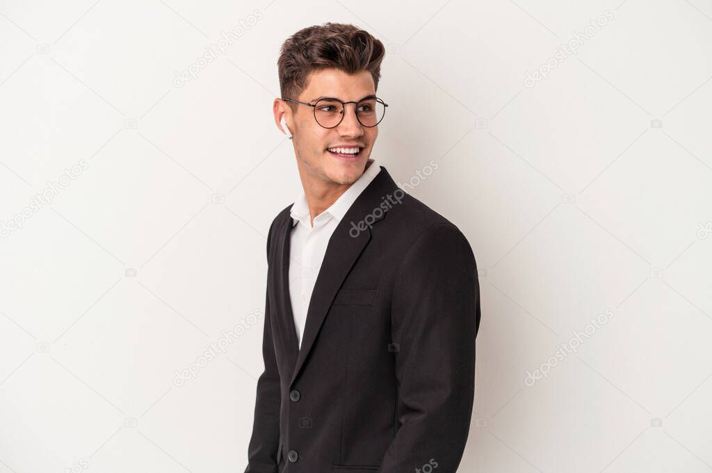 Young business caucasian man wearing headphones isolated on white background looks aside smiling, cheerful and pleasant.