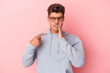 Pembe arka planda izole genç beyaz adam güçlü bir diş ağrısı, azıdişi ağrısı var..