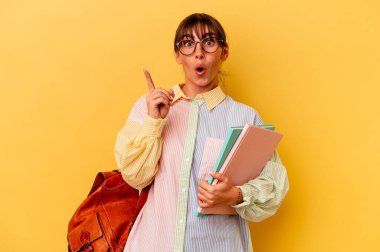 Arjantinli genç bir kadın, sarı arka planda izole edilmiş. Harika bir fikri var, yaratıcılık kavramı..