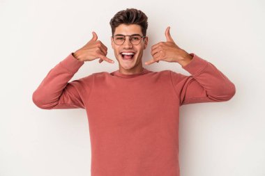 Beyaz arka planda izole edilmiş genç beyaz bir adam parmakları olan bir cep telefonu hareketi gösteriyor..