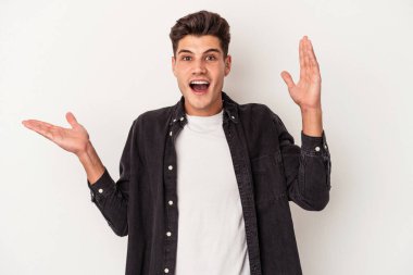 Beyaz arka planda izole edilmiş genç beyaz bir adam bir avuç içinde fotokopi alanı tutuyor, el üstünde tutuyor. Şaşırmış ve mutlu..