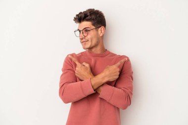 Beyaz arka plan noktalarında izole genç beyaz adam, iki seçenek arasında seçim yapmaya çalışıyor.