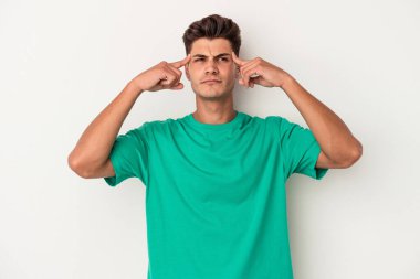 Beyaz arka planda izole edilmiş genç beyaz bir adam bir göreve odaklanmış, işaret parmaklarını işaret ediyor..