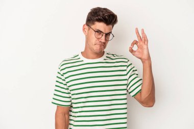 Beyaz arka planda izole edilmiş genç beyaz bir adam bir göz kırptı ve elleriyle iyi bir jest yaptı..