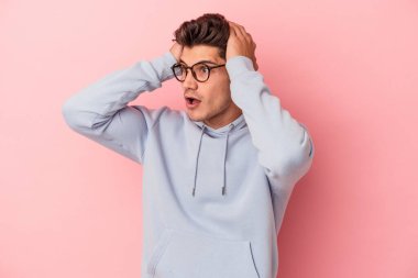 Pembe arka planda izole edilmiş genç beyaz bir adam çığlık atıyor, çok heyecanlı, tutkulu, bir şeyden memnun..