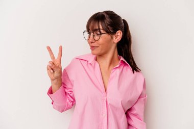 Genç Arjantinli kadın beyaz arka planda izole edilmiş neşeli ve tasasız parmakları olan bir barış sembolü gösteriyor..