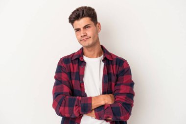 Beyaz arka planda izole edilmiş genç beyaz bir adam şüpheli, belirsiz, seni muayene ediyor..