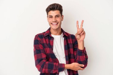 Beyaz arka planda izole edilmiş genç beyaz adam iki numarayı parmaklarıyla gösteriyor..