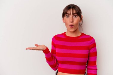 Beyaz arka planda izole edilmiş genç Arjantinli kadın, avuç içinde kopya alanı bulundurmaktan etkilenmiş..