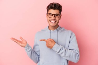 Pembe arka planda izole edilmiş beyaz bir adam. Elinde bir fotokopi odası tutarken heyecanlı..