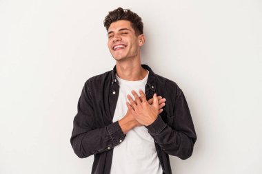 Beyaz arka planda izole edilmiş beyaz tenli genç bir adam, dostane bir ifadeye sahip, avuçlarını göğsüne bastırıyor. Aşk konsepti.