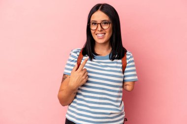 Pembe arka planda tek kollu beyaz bir kadın öğrenci. Sanki seni davet ediyormuş gibi parmakla işaret ediyor..