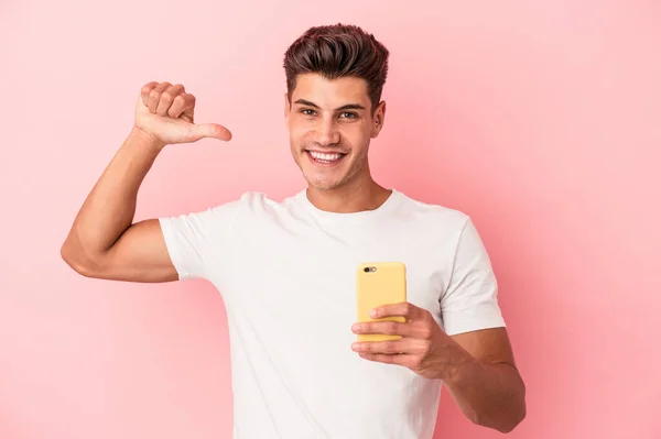 Młody Biały Mężczyzna Trzymając Telefon Komórkowy Odizolowany Różowym Tle Czuje — Zdjęcie stockowe