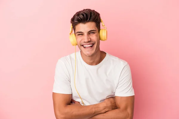 Jonge Blanke Man Luisteren Naar Muziek Geïsoleerd Roze Achtergrond Lachen — Stockfoto