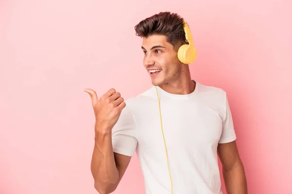 Jonge Blanke Man Luisteren Naar Muziek Geïsoleerd Roze Achtergrond Punten — Stockfoto
