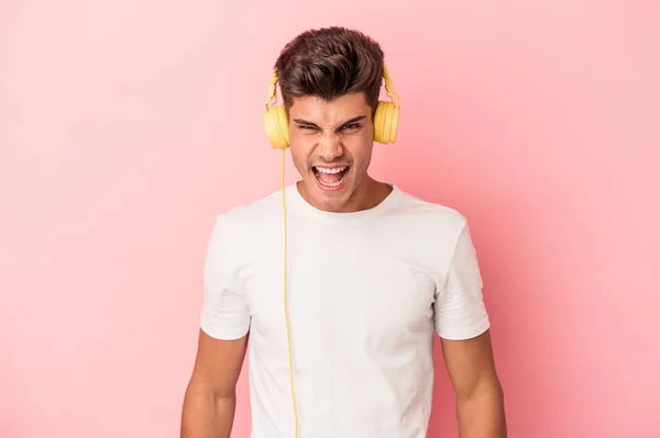 Молодий Кавказький Чоловік Слухає Музику Ізольовано Рожевому Фоні Кричить Дуже — стокове фото