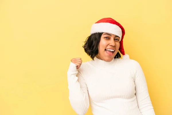 年轻的拉丁女人带着无忧无虑的笑容 用手指在黄色的背景点上欢度圣诞节 — 图库照片