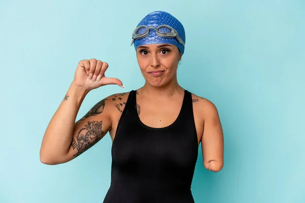 年轻的游泳者高加索女人 一只胳膊被蓝色背景隔离 露出不喜欢的姿势 大姆指朝下 不同意的概念 — 图库照片