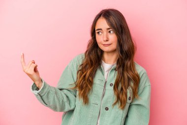 Pembe arka planda izole edilmiş genç beyaz kadın sanki seni davet ediyormuş gibi seni işaret ediyor..