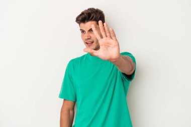 Beyaz arka planda izole genç beyaz adam yakın bir tehlike nedeniyle şoka uğruyor