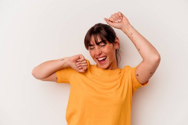 Arjantinli genç bir kadın beyaz arka planda izole edilmiş özel bir günü kutluyor, atlıyor ve enerjiyle kollarını kaldırıyor..