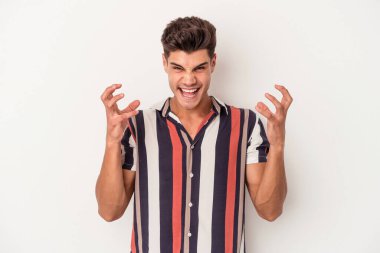 Beyaz arka planda izole edilmiş genç beyaz bir adam öfkeyle bağırıyor..