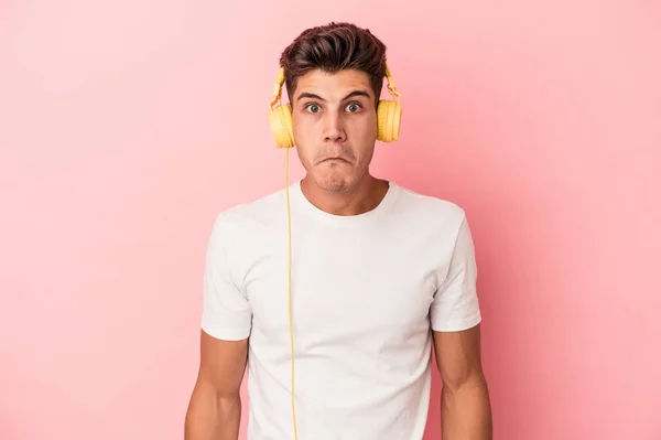 Jeune Homme Caucasien Écoutant Musique Isolée Sur Fond Rose Haussant — Photo