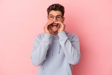 Pembe arka planda izole edilmiş genç beyaz bir adam bir dedikodu söylüyor, bir haber sunuyor..