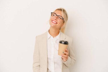 Genç iş kadını elinde kahve tutuyor. Beyaz arka planda izole edilmiş. Amaçlarına ve amaçlarına ulaşma hayalleri kuruyor.