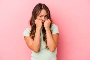 Pembe arka planda izole edilmiş genç beyaz kadın bir tartışma yüzünden yumruk, öfke, kavga ve boks atıyor..