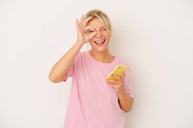 Beyaz arka planda cep telefonu tutan genç Rus kadın heyecanlı..